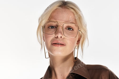 Preview: Stylish blonde woman showcasing winter fashion in a bright studio setting