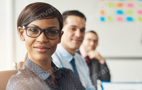 Preview: Smiling woman seated with men in meeting