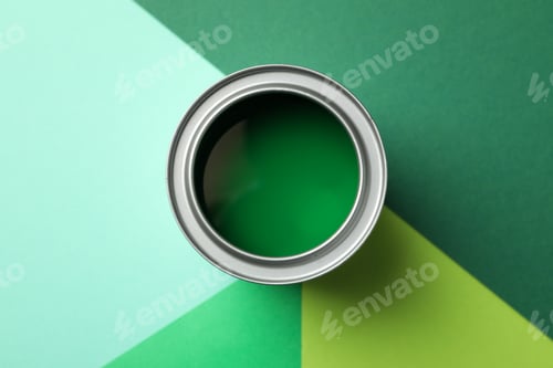 Preview: Can of green paint on multicolored background, top view