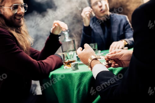Preview: selective focus of player holding watch while playing poker on black
