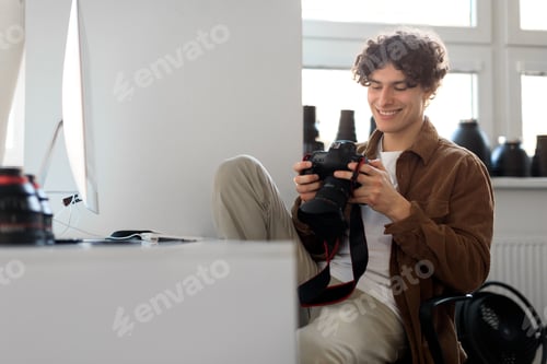 Preview: Modern arts and creative career concept. Happy handsome professional photographer guy holding camera