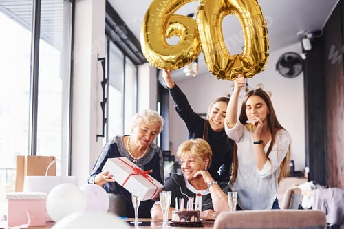 Preview: Balloons with number 60. Senior woman with family and friends celebrating a birthday indoors