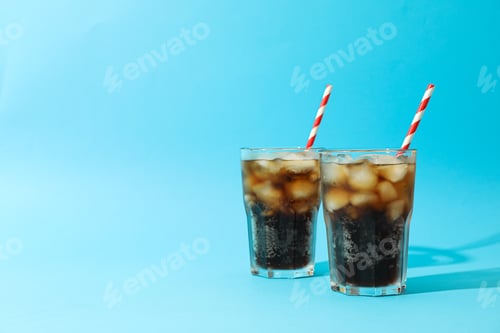 Preview: Glasses with cold cola and tubule on blue background, space for text