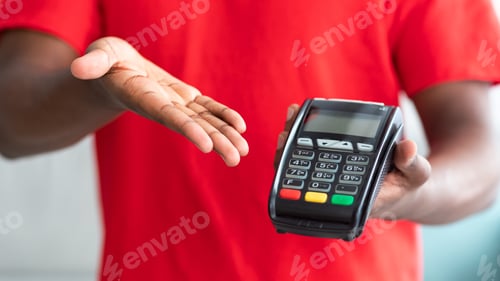 Preview: Cropped view of black man in uniform holding POS machine