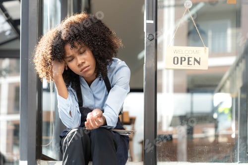Preview: black woman waiter of street cafe is waiting for clients, customersm she is bored, no people in