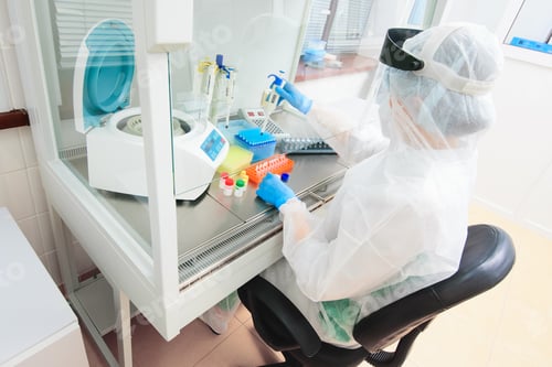 Preview: a female PCR laboratory researcher in a protective medical suit