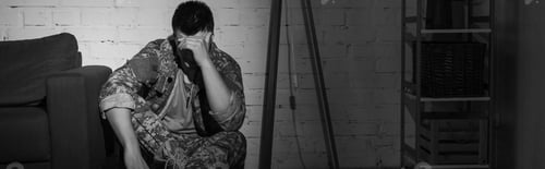 Preview: Black and white photo of military veteran suffering from emotional distress at home, banner