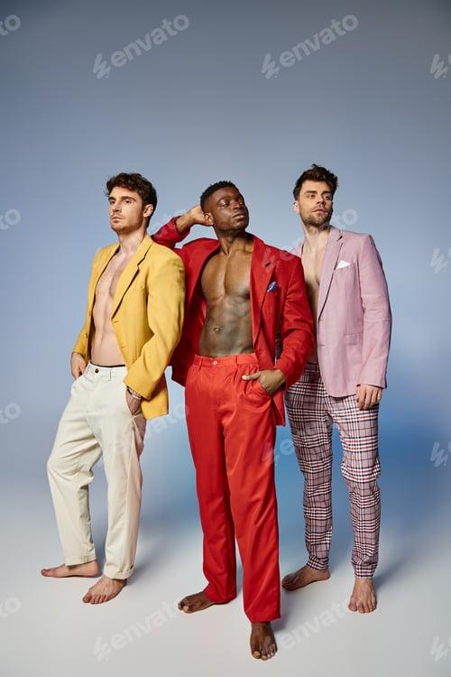 Preview: appealing sexy diverse men in unbuttoned vibrant suits posing on gray backdrop, fashion concept