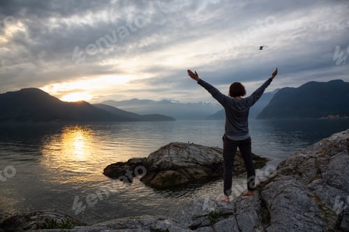 Preview: Woman enjoying the Canadian Mountain Landscape during a vibrant sunset