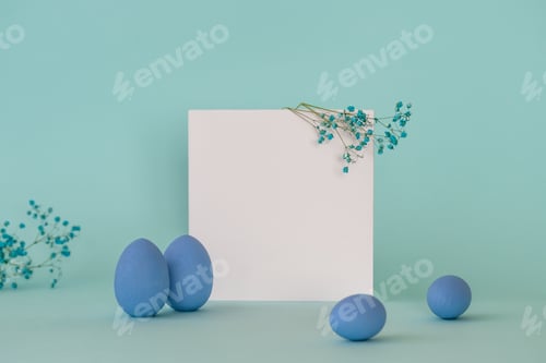 Preview: Easter composition with decorative blue eggs and twigs of blue flowers placed near square blanc