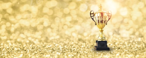 Preview: 1st champion award, championship cup or winner trophy on golden floor with bokeh background