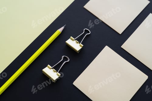 Preview: flat lay of blank paper near sticky notes, pencil and fold back clips on black
