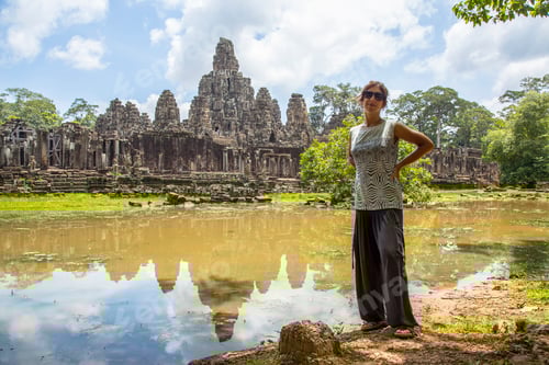 Preview: A woman in Bayan temple reflected in the water in Angkor Wat