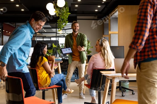 Preview: Caucasian casual businessman presenting to diverse colleagues using tablet in office