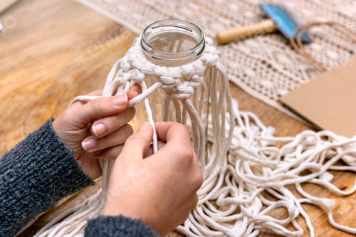 Preview: Macrame. Woman weaves home decor from cotton thread macrame pattern.Handmade in macrame technique