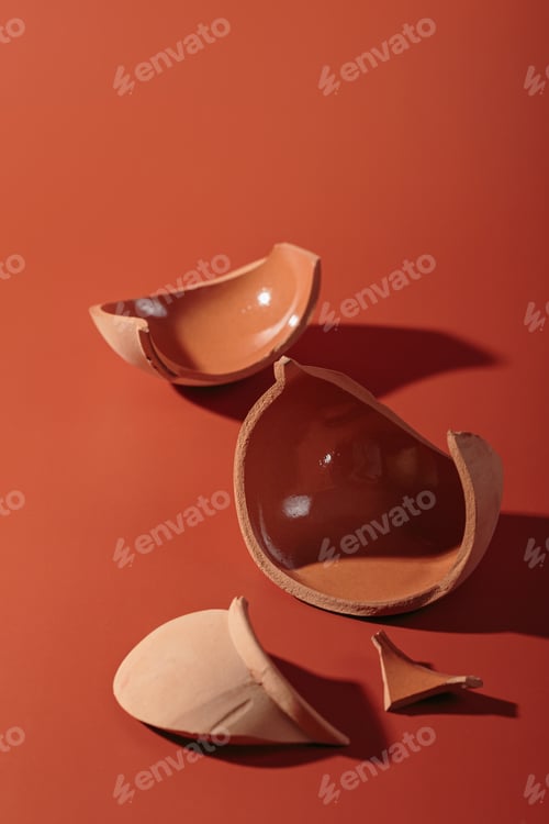 Preview: Details of broken ceramic cup on red background