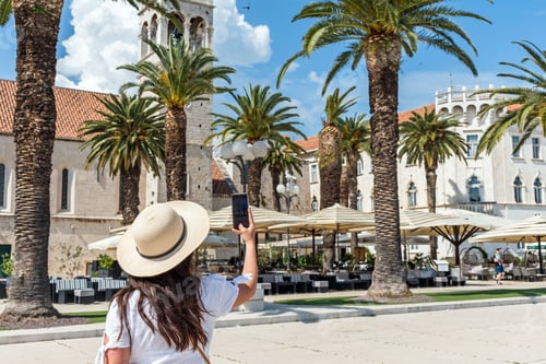 Preview: Female tourist taking photos of the church and monastery of St. Dominic in Trogir, Croatia
