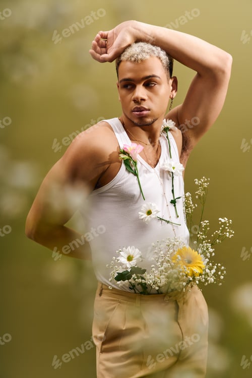 Preview: Fashionable young man with dyed hair poses with flowers in a stylish studio setting