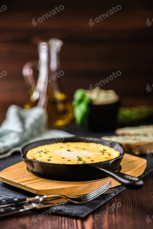 Preview: Omelette in frying pan with bread and herbal butter