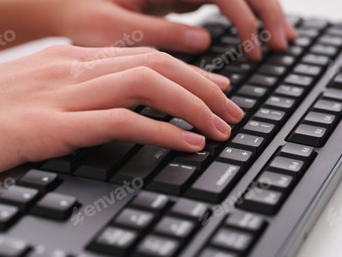 Preview: A young man typing on a black computer keyboard
