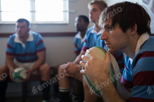 Preview: Rugby team looking away while sitting in locker room