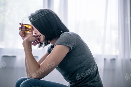 Preview: upset lonely woman with whiskey glass at home