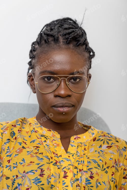 Preview: Confident African American female with braided hairstyle and in glasses looking at camera at home
