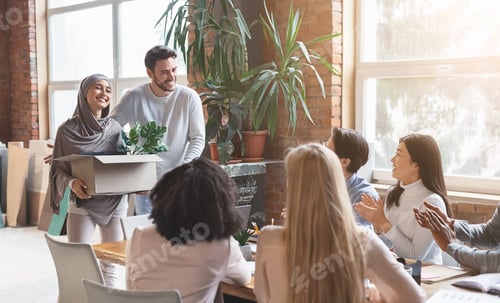 Preview: Young multiracial business team welcoming newcomer woman in hijab