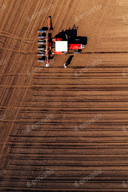 Preview: Aerial view of farmer and tractor with crop seeder