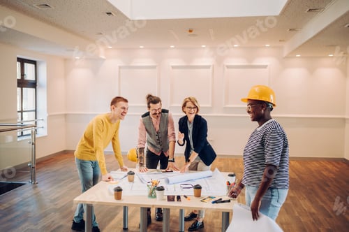 Preview: Multiracial team of architects having a meeting while using blueprints