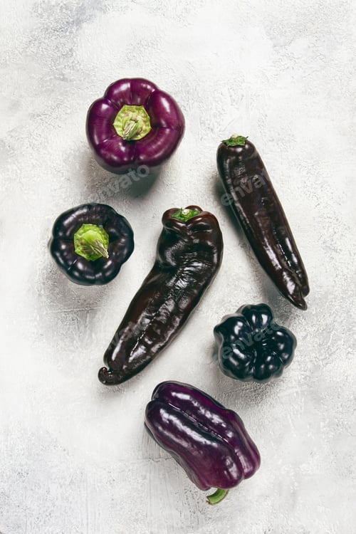 Preview: Assortment of purple and black pepper , scattered on the table, top view, no people,