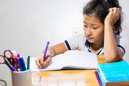 Preview: student, very bored and stressed out doing her homework. little girl writing on her wooden desk