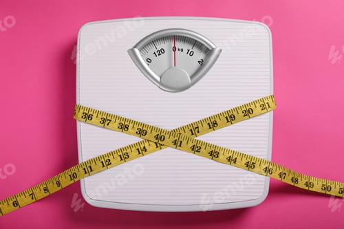 Preview: Weight loss concept. Scales and measuring tape on pink background, top view