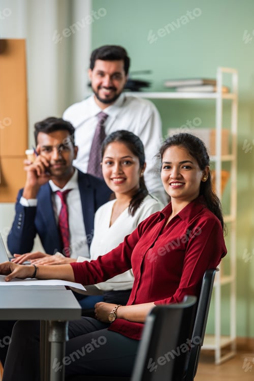 Preview: Indian young businesspeople using laptop in group meeting at desk