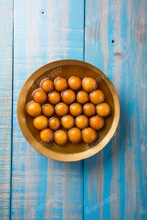 Gulab Jamun Dessert in Golden Bowl on Wood