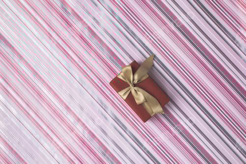 Preview: top view of christmas gift box with ribbon on patterned wrapping paper