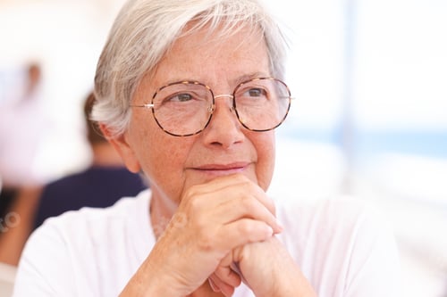 Preview: Close up portrait of a beautiful pensive senior caucasian woman with white hair and eyeglasses