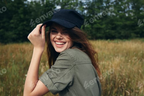 Preview: Happy woman in blue cap and green shirt laughs