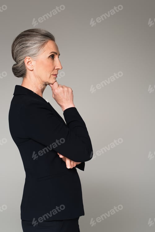Preview: Side view of pensive mature businesswoman looking away isolated on grey
