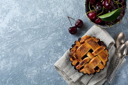 Preview: Homemade open cherry pie with lattice on a gray concrete background. Selective focus. Top view