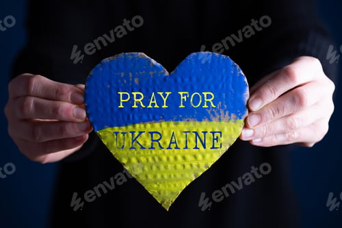 Preview: Heart flag of Ukraine in human hands. No war, peace for Ukraine concept.