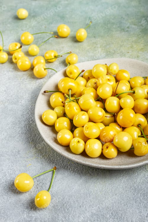 Preview: yellow cherry, cherry berry, scattered on a plate, top view, no people,