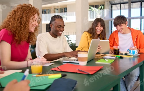 Preview: Smiling young people doing homework using laptop tablet in college campus cafeteria. Generation z.