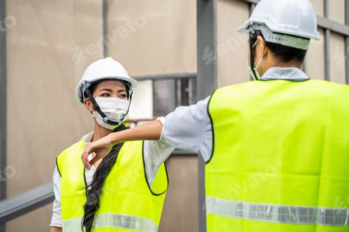 Preview: Asian workers engineers making elbow touch instead of handshake to avoid coronavirus infection.