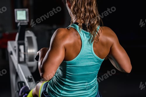 Preview: Woman athlete exercising on rowing machine