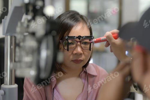Preview: Young woman checking her eyesight and choosing glasses