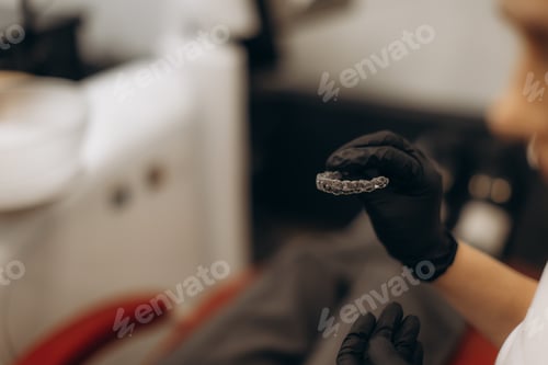 Preview: Close-Up of Dentist Holding a Retainer in Dental Office Setting