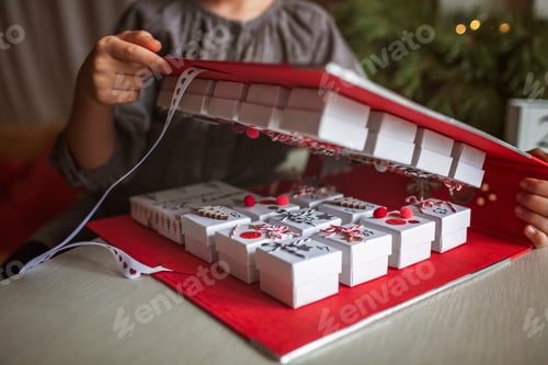 Preview: Pretty girl holds original advent calendar made of jewelry boxes and binder, Christmas diy craft