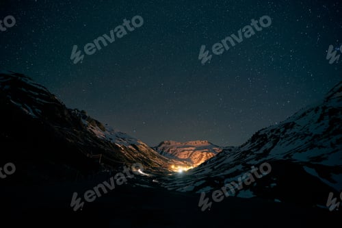 Preview: Bright illumination amidst mountains at night