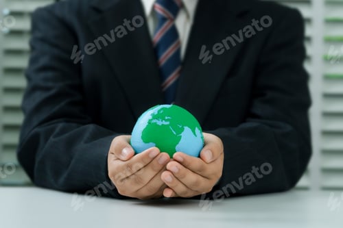 Preview: Businesshand holding green earth with renewable energy. Carbon emission low neutral, net zero, ESG.
